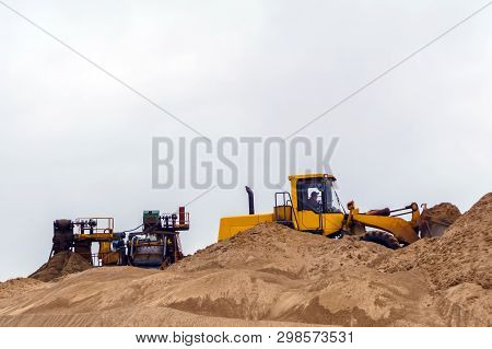 Stationary Rusty Gravitational Sand And Gravel Separator And Bucket Loader On The Background