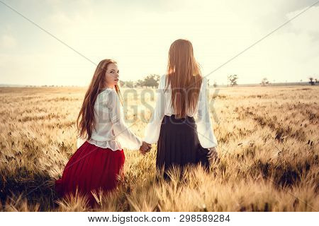 Two Young Women Are Looking Forward Tothe Sunset. Best Friends