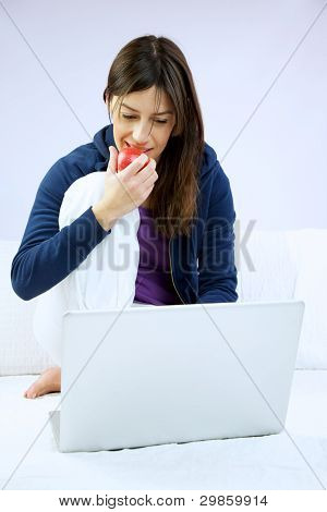 여 자가 웃 고 먹고 애플 컴퓨터 앞에 앉아