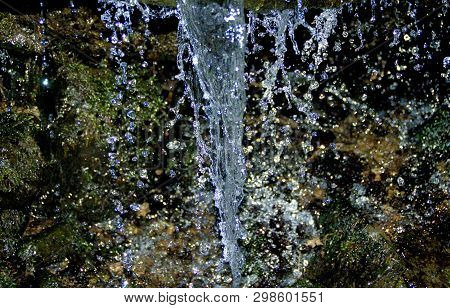 Waterfall With Drops Almost Froozen In Falling During Cold Vinter. Shiny Dark Backgruond, But Colorf