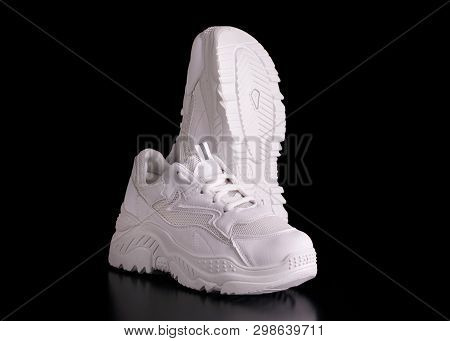 White Sneakers On A Black Background. Fashionable Sneakers With Thick Soles. White Running Shoes