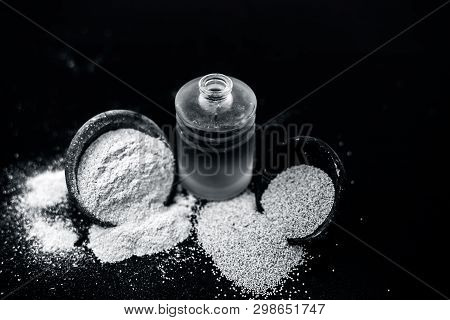 Close Up Of Organic Oil Of Poppy Seeds Or Khus Khus In A Small Glass Bottle With Raw Poppy Seeds And