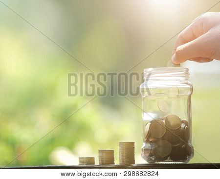 Hand Drop Money Coins To Jar. Saving Money Concept.