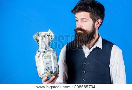 He Respects Money. Bearded Man Keeping Money In Glass Jar. Hipster Holding Jar With American Money. 