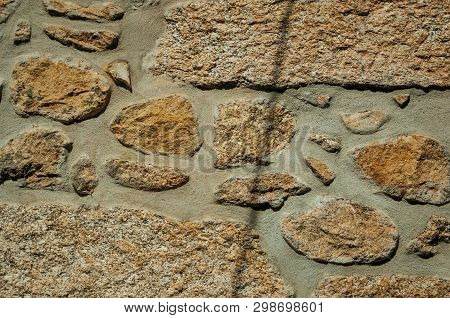Close-up Of Old Wall Made Of Large Rough Stones Forming A Charming Background, In A Sunny Day At Unh