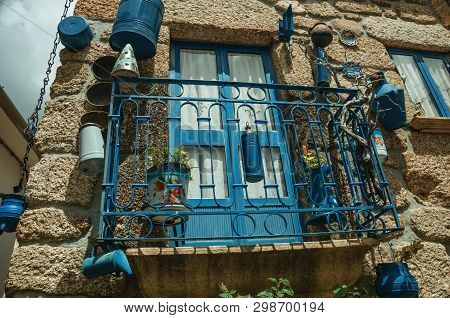 Wrought Iron Railing Balcony Decorated With Lots Of Blue Pans On Stone House Facade At Alvoco Da Ser