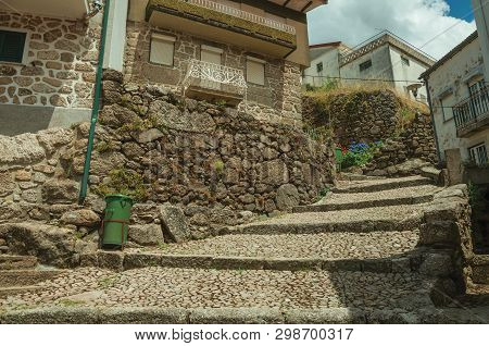 Facade Of Old Stone Houses In Cobblestone Alley On Slope With Steps, In A Sunny Day At Alvoco Da Ser