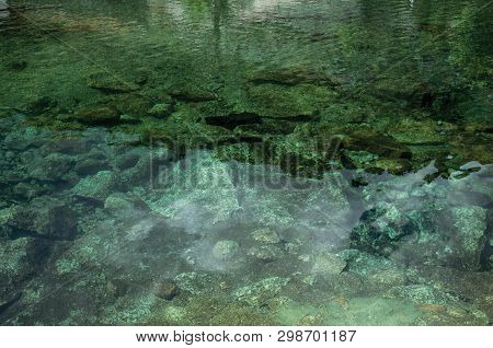 Crystal Clear Water In Small Pond With Stones On The Bottom, In A Cloudy Day Near Loriga. Known As T