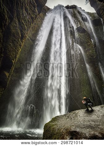 21 April 2018: South Iceland - Gljufrabui Waterfall, And A Man Taking A Photo With His Cell Phone.