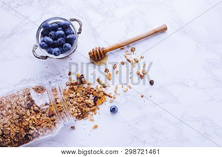 Delicious Homemade Granola In Glass Jar, Agave Nectar And Fresh Blueberries On Marble Background. He