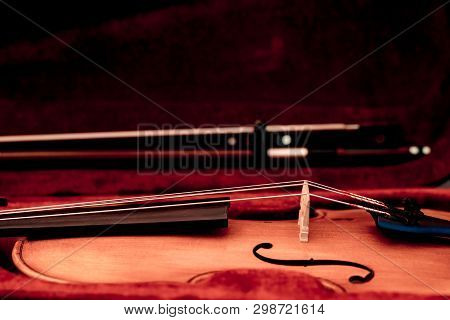 Violin And Bow In Dark Red Case. Close Up View Of A Violin Strings And Bridge