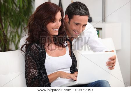Paar kijken naar foto's op hun laptop en herinneringen
