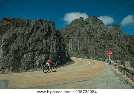 Road Passing Through Rocky Landscape With Cyclist