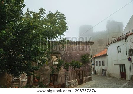 Guarda, Portugal - July 20, 2018. Cathedral Behind Worn Old Houses On Alley, In The Morning Mist Of 