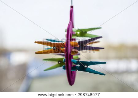 Multi-colored Clothespins Are Attached To A Hanger For Storing Shawls, Scarves And Stoles. Selective