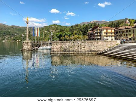 The Old Port With The Statue Of Madonnina In Luino, Located On The Coast Of Lake Maggiore, Italy
