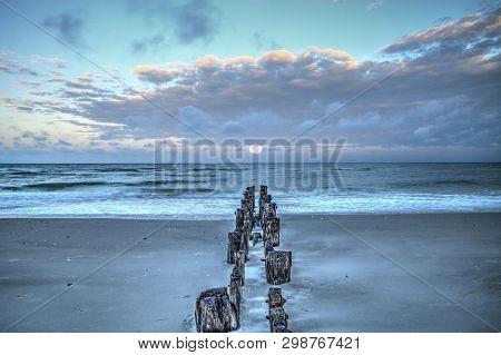 Moonset At Dawn Over A Dilapidated Pier On The Beach In Port Royal