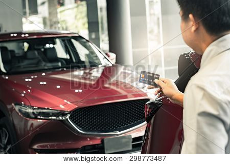 Asian Man Holding Credit Card For Car Blurred Bokeh Background E-shopping 
Marketing Digital, Consum