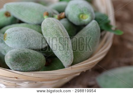 Fresh Green Unripe Almonds In Basket On Wooden Table