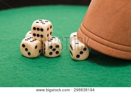 Dices And A Gmaing Shaker On A Green Background. Gaming, Luck And Risk Concept.