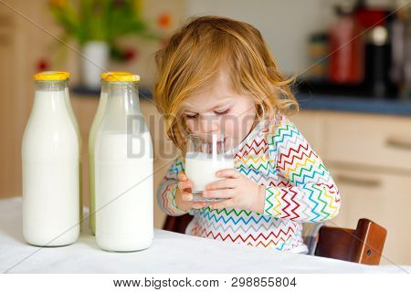 Adorable Toddler Girl Drinking Cow Milk For Breakfast. Cute Baby Daughter With Lots Of Bottles. Heal