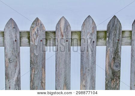 A Gray Wood Pickett Fence Closeup Appears.