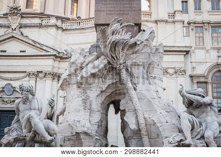 Statues At The Foot Of The Obelix Of Piazza Navona In Rome Italy At Evening