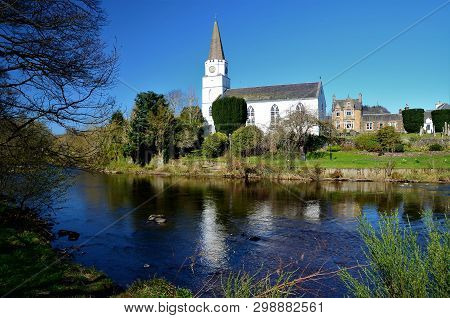 A View Of The White Church Building On The Banks Of The River Earn In Comrie, Perthshire
