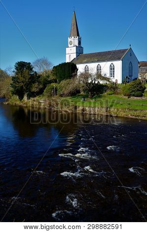 A View Of The White Church Building On The Banks Of The River Earn In Comrie, Perthshire