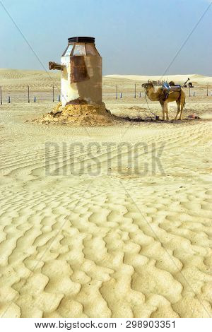 Landscape Of Camel And Tank In Ong Jemel Desert In Tunisia.