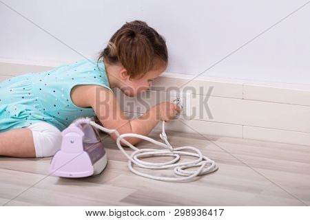 Toddler Trying To Insert Iron Wire In Electric Plug At Home