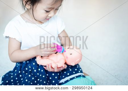 Adorable Sweet Asian Little Baby Child Playing Doll, Feeding Bottle Milk To Baby Doll