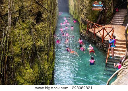XCARET,MEXICO - APRIL 16,2019 : Visitors enjoying the underground river at the XCaret park on the Mayan Riviera