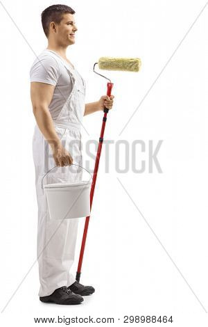 Full length profile shot of a wall painter guy holding a backet isolated on white background