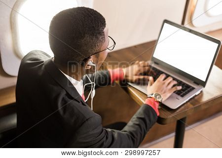 Attractive And Successful African American Businessman With Glasses Working On A Laptop While Sittin