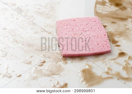 Pink Sponge On A Counter Top Or Floow Covered With Spills