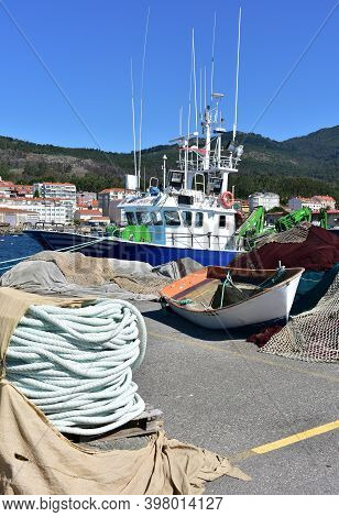 Portosin, Spain. July 3, 2020. Harbor With Galician Fishing Vessel And Old Row Boat. A Coruña Provin