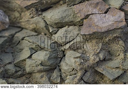 Fragment Of A Rock Layer In The Form Of Gray Dark Green Sharp Stones Sprinkled With Coarse Sand