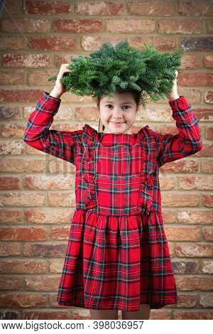 Little Girl Iputting Green Christmas Wreath On Her Head
