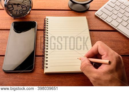 Hand Writing On Blank Notebook On Wood Table With Coffee Supply, Smartphone