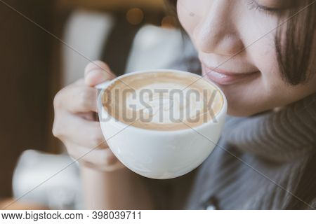 Woman Hand Holding A Cup Of Hot Latte Art