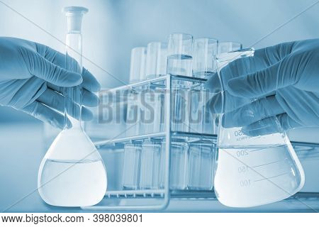 Flask In Scientist Hand With Dropping Chemical Liquid To Test Tubes, Science And Medical Research An