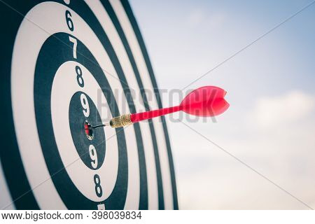 Red Dart Arrow Hitting In The Target Center Of Dartboard