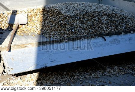 Delivery Of Gray River Pebbles Like Mulch To Flower Beds In The Garden Using A Wheelbarow From The B