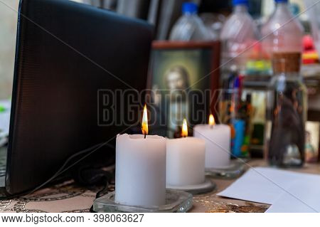 Modern Workplace Of A Magician, Sorcerer, Psychologist. Three Lighted White Candles. Icons, Laptop, 