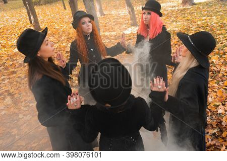 Coven Of Witches, A Group Of Friends As Witches On Halloween Perform A Ritual, Lead A Round Dance An