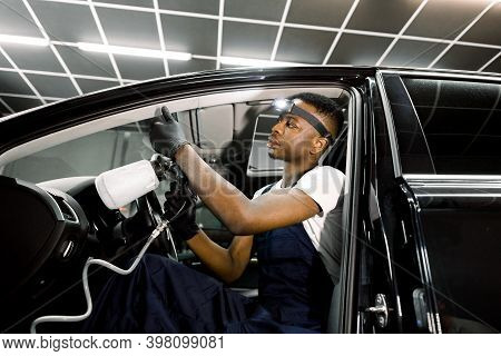 Professional Chemical Cleaning Of Interior Of Luxury Car By Air Gun. Male African Worker Of Auro Ser