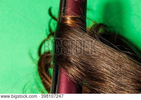 Women's Long Hair Is Wrapped On A Hot Styler. Close-up, Selective Shot.