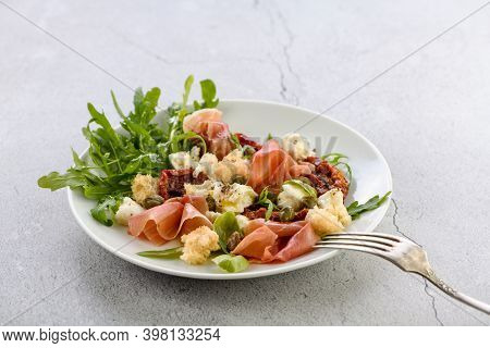 Salad Arugula, Parma Ham With Sun-dried Tomatoes, Mozzarella Slices, Croutons, Capers, Seasoned Oil 