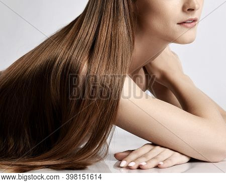 Close-up Of Silky Long Straight Hair Of Young Beautiful Woman Model Lying And Posing Over White Back